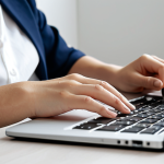 A focused female professional, fully clothed in a modest business casual outfit, sitting at a clean, minimalist desk in a bright, modern home office. She is working efficiently on a laptop, with a neatly organized notebook and pen beside her, symbolizing streamlined processes and resourceful work. The lighting is soft and natural. Perfect anatomy, correct proportions, natural pose, well-formed hands, proper finger count, natural body proportions. Professional photography, high-resolution, sharp focus. Safe for work, appropriate content, fully clothed, modest, family-friendly.